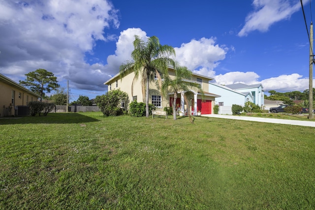 view of front of property with driveway, an attached garage, fence, a front yard, and stucco siding