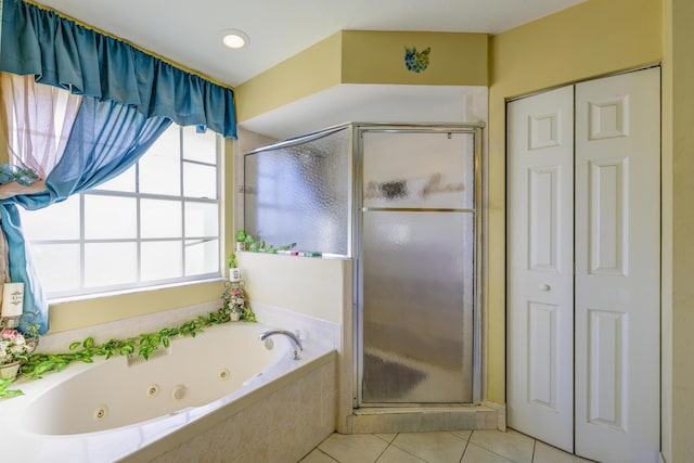 bathroom featuring a closet, a stall shower, tile patterned flooring, and a jetted tub