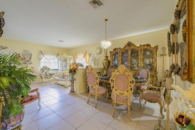 tiled dining area featuring an inviting chandelier and visible vents