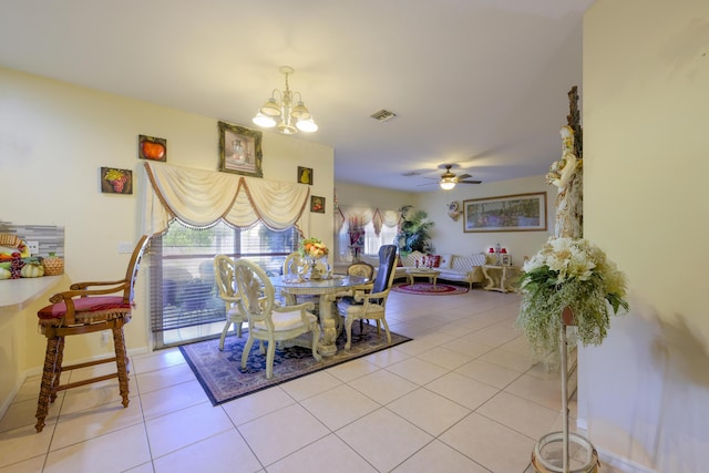 dining room featuring ceiling fan with notable chandelier, visible vents, baseboards, and light tile patterned floors