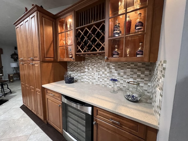 bar with beverage cooler, tasteful backsplash, a bar, and tile patterned floors