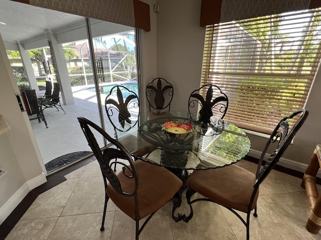 tiled dining room featuring baseboards