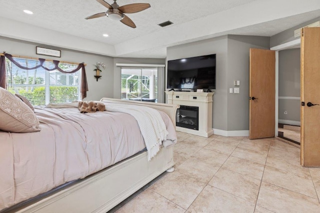 bedroom featuring visible vents, a textured ceiling, baseboards, and multiple windows