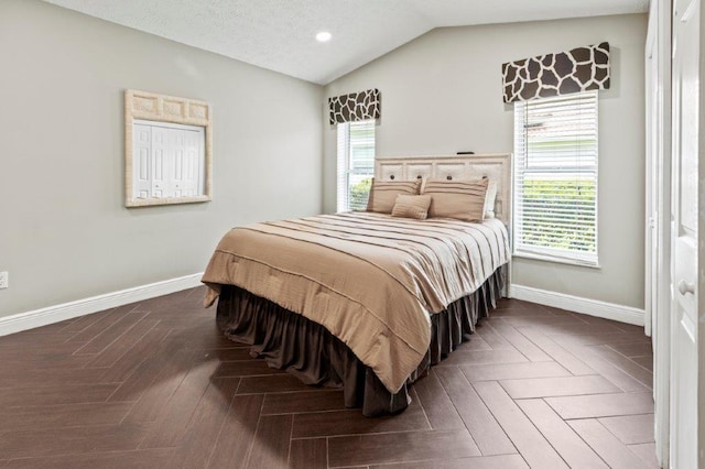 bedroom with lofted ceiling, multiple windows, and baseboards