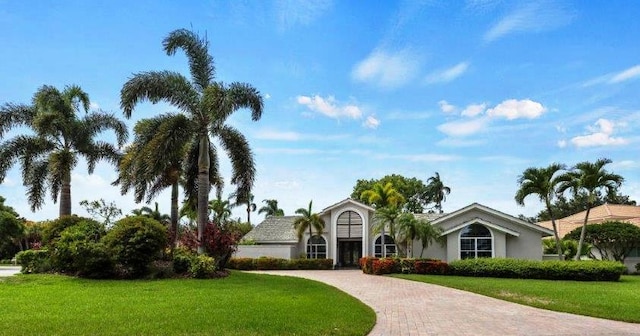 view of front of home featuring a front yard and decorative driveway