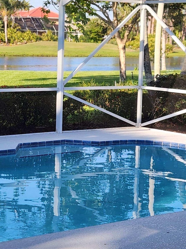 outdoor pool with glass enclosure and a water view