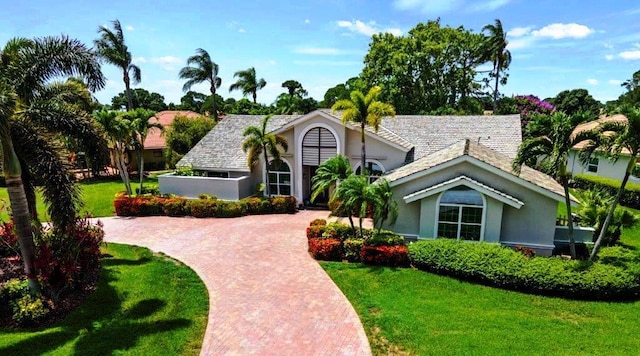 view of front of house with a front lawn, decorative driveway, and stucco siding