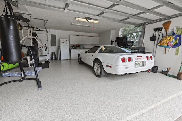 garage featuring freestanding refrigerator and electric panel