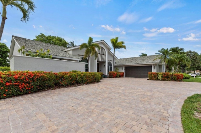 ranch-style home with driveway, an attached garage, and stucco siding