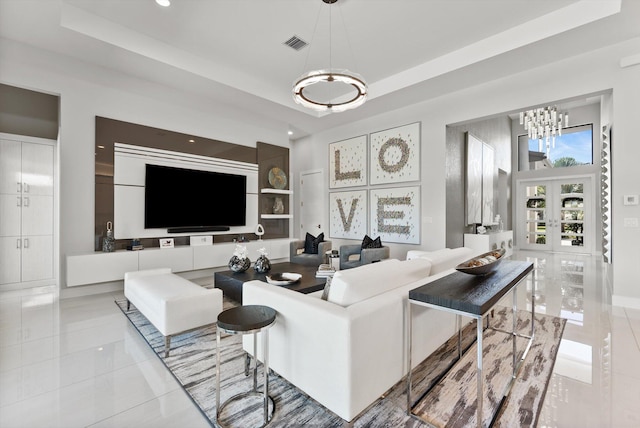 living room with light tile patterned floors, visible vents, and a tray ceiling