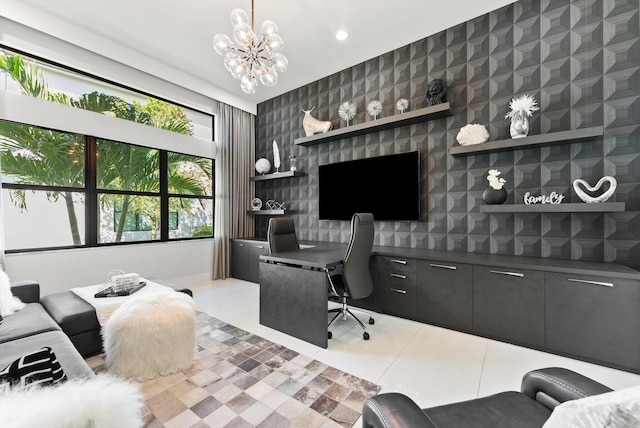 home office featuring wallpapered walls, an accent wall, a notable chandelier, and light tile patterned flooring