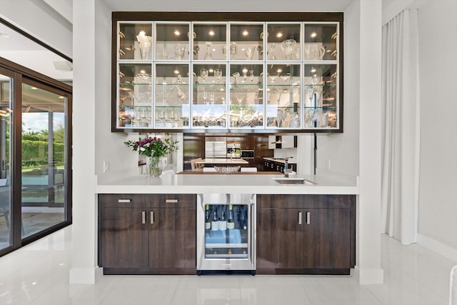 bar featuring a sink, light tile patterned floors, beverage cooler, and indoor wet bar