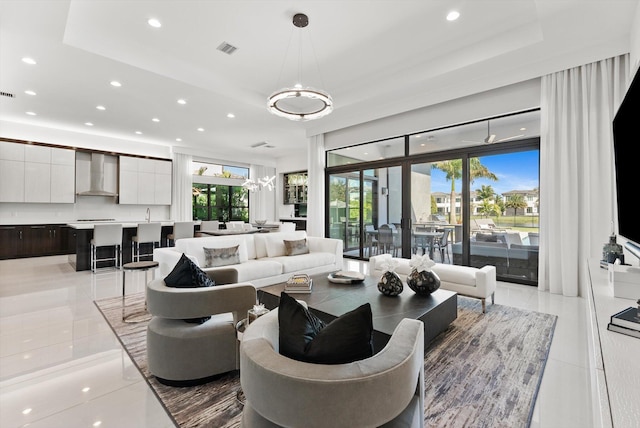 living area featuring plenty of natural light, visible vents, and a tray ceiling