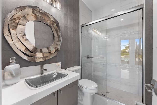 bathroom with a stall shower, vanity, and toilet