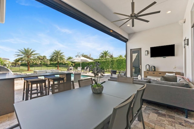 view of patio / terrace with an outdoor pool, ceiling fan, an outdoor hangout area, fence, and outdoor dining space