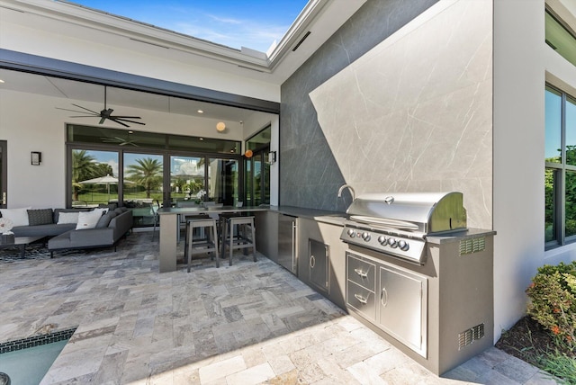 view of patio / terrace with ceiling fan, an outdoor kitchen, a grill, and an outdoor living space