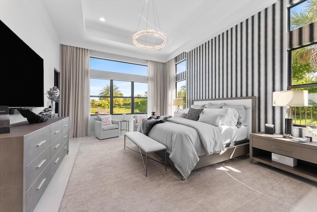 bedroom featuring a high ceiling, a raised ceiling, and recessed lighting