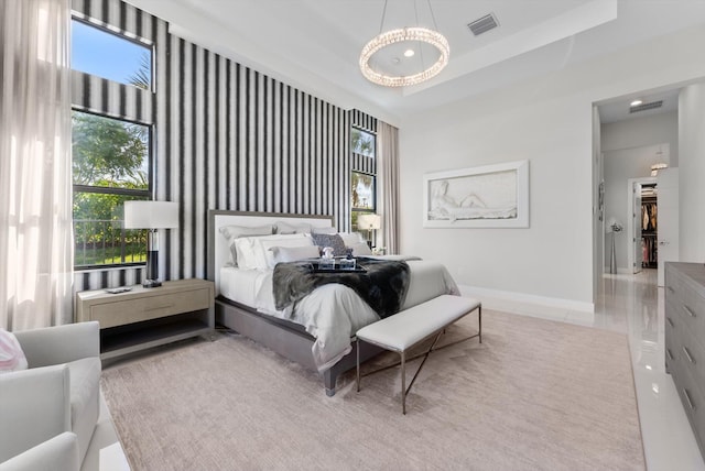 tiled bedroom with a raised ceiling, visible vents, and baseboards