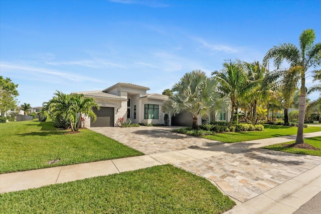 view of front facade featuring a garage, a front yard, and decorative driveway