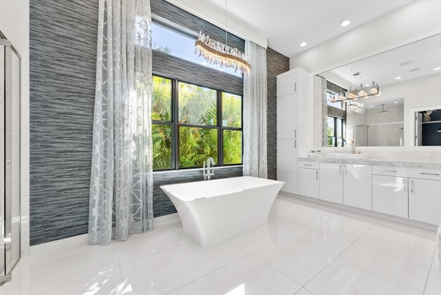 bathroom with a walk in shower, recessed lighting, vanity, a soaking tub, and tile patterned floors