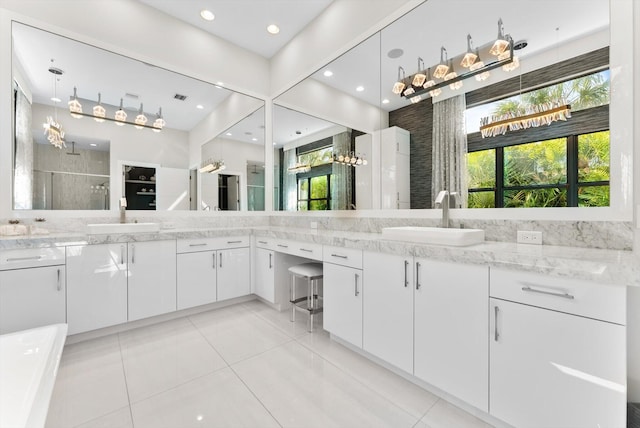 full bath featuring a stall shower, two vanities, and a sink