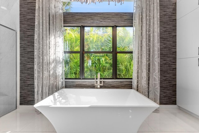 full bathroom featuring a freestanding tub, tile walls, and tile patterned floors