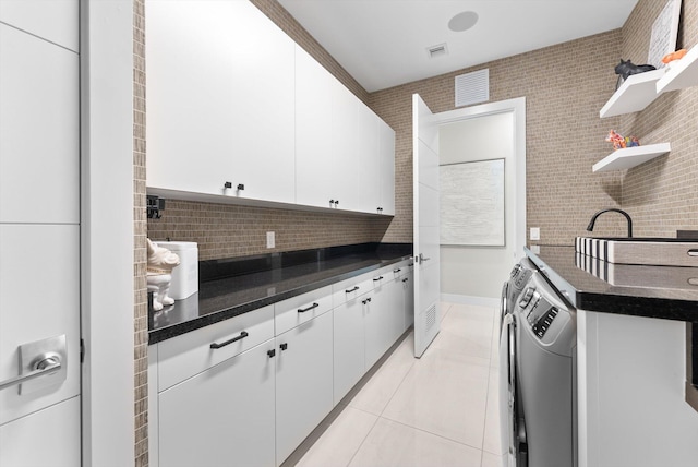 kitchen featuring light tile patterned floors, open shelves, white cabinetry, and washer and dryer