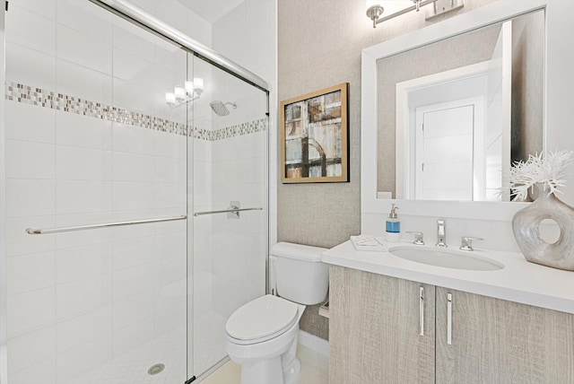 bathroom with a stall shower, vanity, and toilet