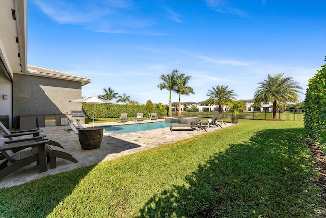 view of swimming pool with a fenced backyard, a pool with connected hot tub, a lawn, and a patio