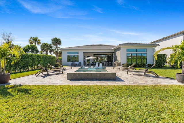 back of house featuring a yard, a fenced in pool, a patio, and stucco siding