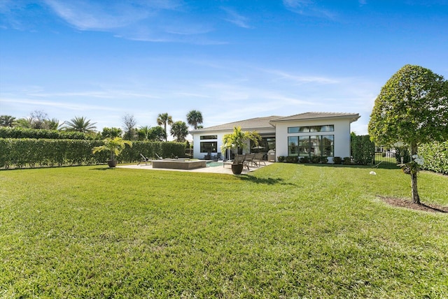 back of house with a patio, a lawn, fence, and stucco siding