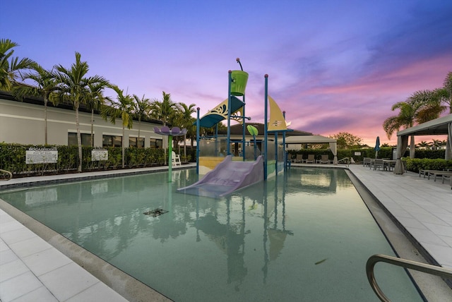 pool at dusk featuring a patio area