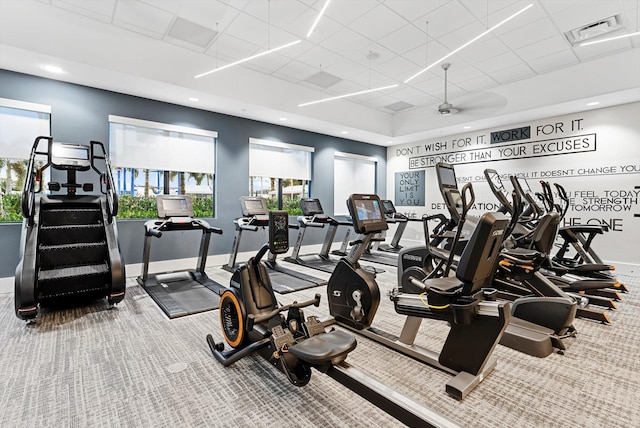 exercise room featuring carpet floors, a wealth of natural light, visible vents, and baseboards