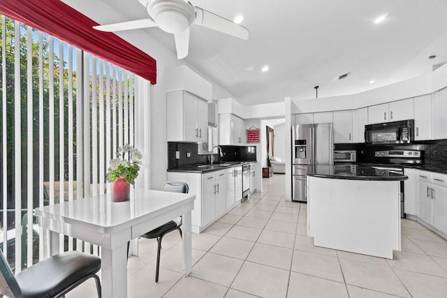 kitchen featuring appliances with stainless steel finishes, dark countertops, decorative backsplash, and light tile patterned floors