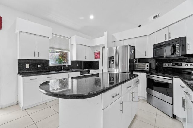 kitchen featuring appliances with stainless steel finishes, light tile patterned floors, visible vents, and tasteful backsplash