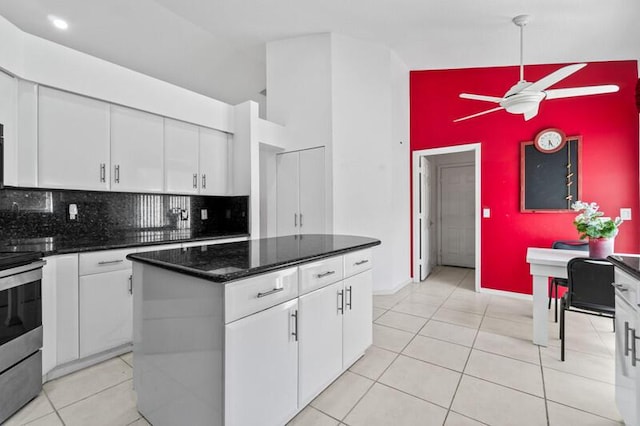 kitchen featuring stainless steel electric range oven, a kitchen island, and white cabinets