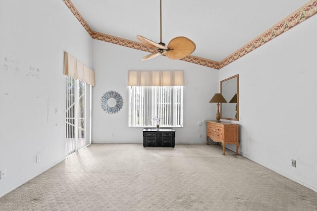 empty room with carpet floors, vaulted ceiling, and a ceiling fan