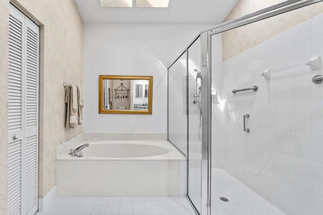 full bathroom featuring a closet, tile patterned flooring, a garden tub, and a stall shower