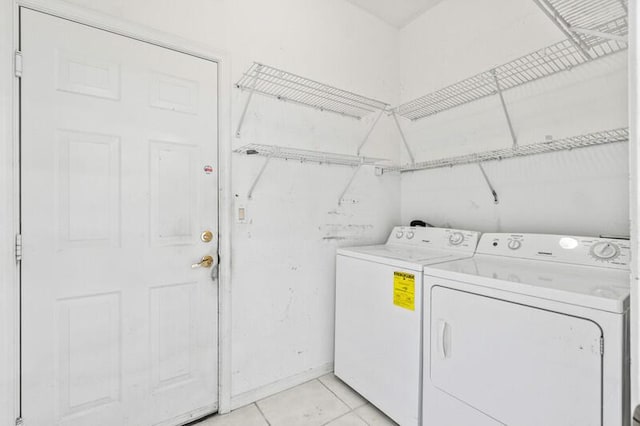 laundry area featuring laundry area, washing machine and dryer, and light tile patterned floors