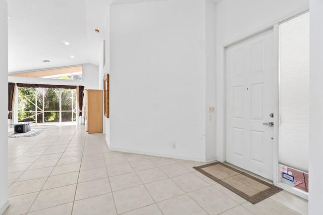 entryway with vaulted ceiling and light tile patterned floors