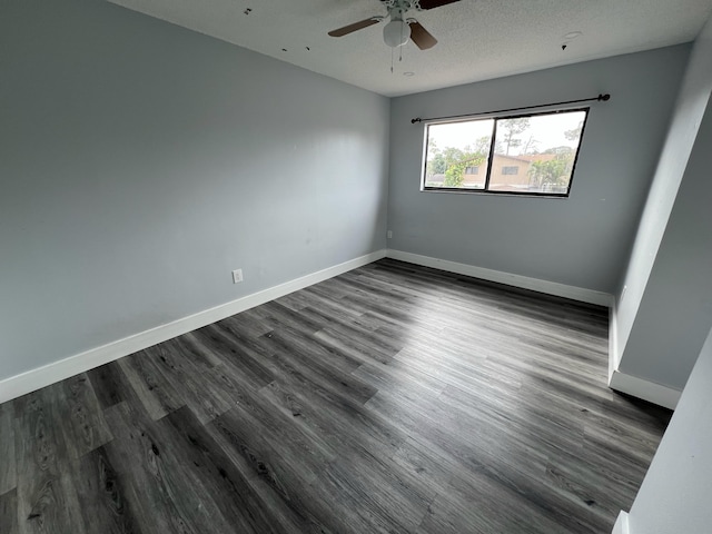 empty room featuring dark wood-type flooring, ceiling fan, a textured ceiling, and baseboards