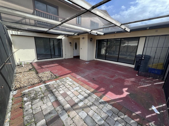 view of patio featuring glass enclosure