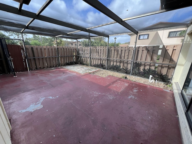 view of patio / terrace featuring glass enclosure and fence