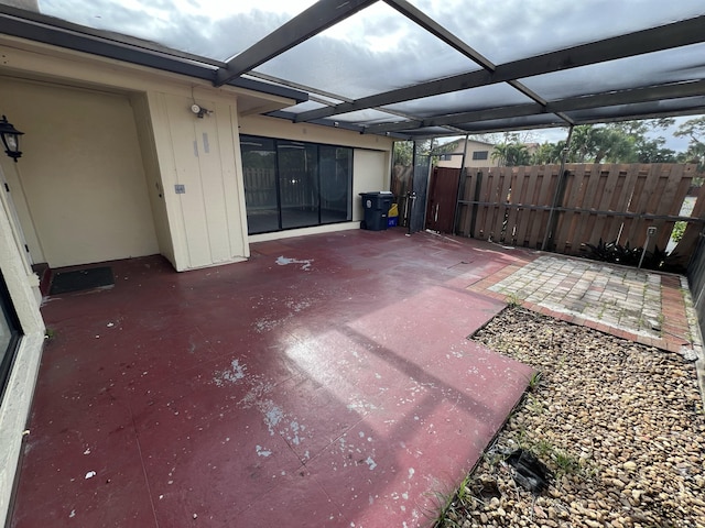 view of patio with glass enclosure and fence