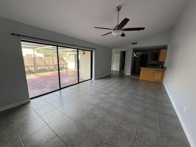 unfurnished living room featuring lofted ceiling, tile patterned flooring, a ceiling fan, baseboards, and stairway