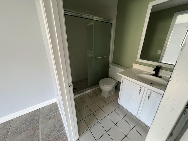 bathroom with a stall shower, baseboards, toilet, tile patterned flooring, and vanity