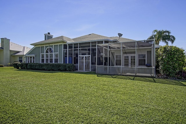 4408 Gator Trace Ln, Fort Pierce, FL 34982 - back of house with a lawn, a chimney, a sunroom, and french doors