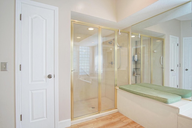 full bath with a shower stall and wood finished floors