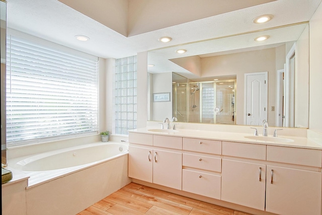 4408 Gator Trace Ln, Fort Pierce, FL 34982 - full bathroom featuring double vanity, a stall shower, a bath, wood finished floors, and recessed lighting