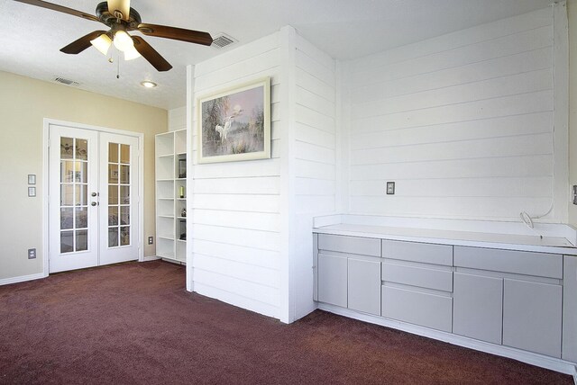 interior space with visible vents, dark carpet, a ceiling fan, and french doors